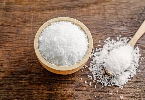 A close up photo of a MSG powder in a bowl and spoon.