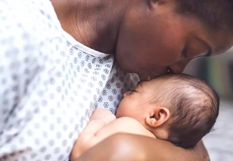 Person holding newborn infant after birth.