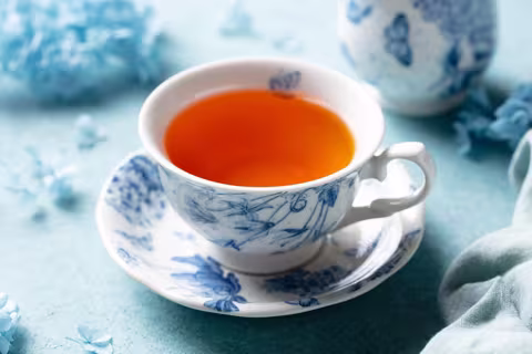 Hot tea in teacup on saucer on table