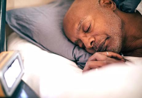 Person sleeping in bed with their head on a pillow