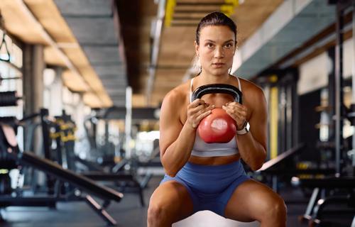 Person using a kettlebell to workout in a gym