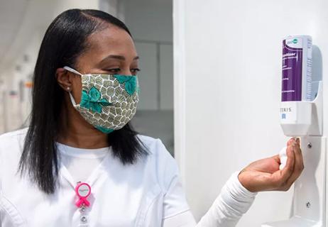 Masked nurse practices hand hygiene