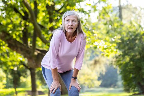 Person outside, bent forward with hands on knees, catching their breath