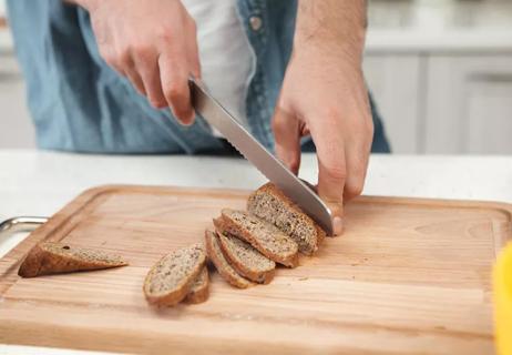 woman slicing healthy bread with nuts