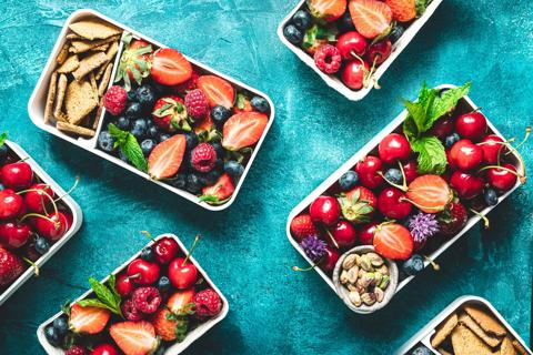 Containers of healthy fruit, nut and whole-wheat cracker snacks