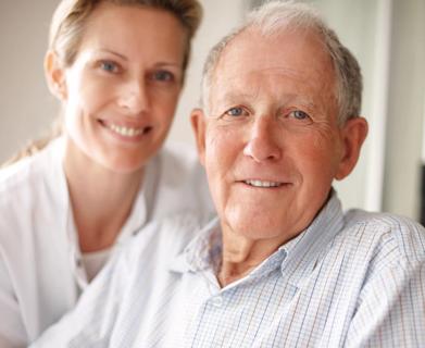 Elderly man on the wheelchair with a nurse