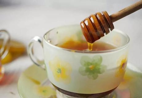 raw honey poured into tea cup