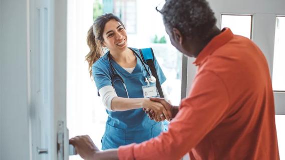 healthcare worker greeting a man at his front door