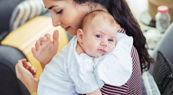 Caregiver burping a baby on their shoulder
