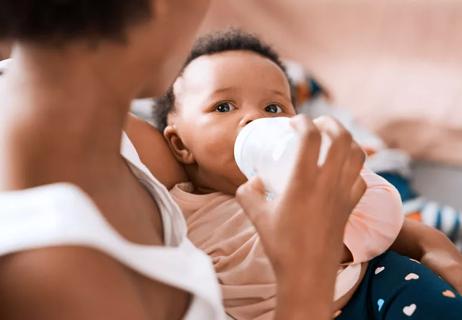 mother bottle feeding her baby milk