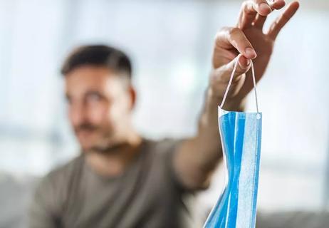 Man holding face mask away from him