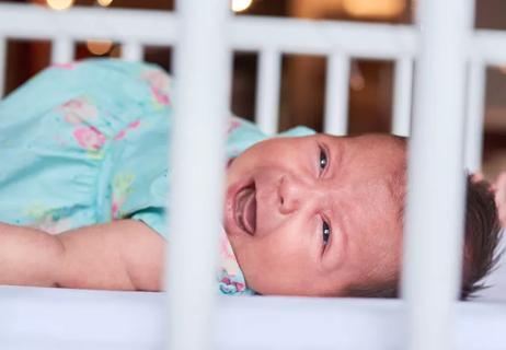 Crying baby in crib