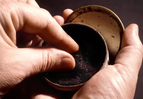 man taking a dip of chewing tobacco or snuff