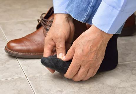man massaging feet hurting from tight shoes