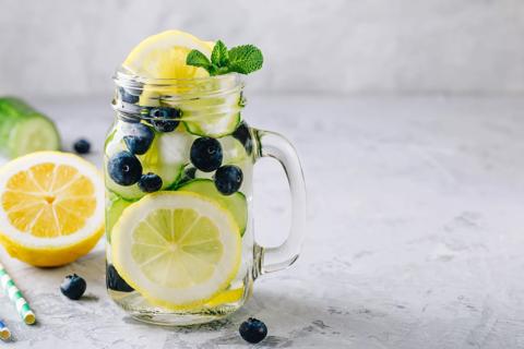 Water in mason jar mug with cucumber, blueberries and lemon