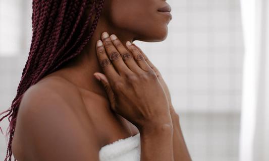 Woman in a towel massaging neck