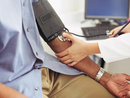 Female doctor taking patient&#8217;s blood pressure