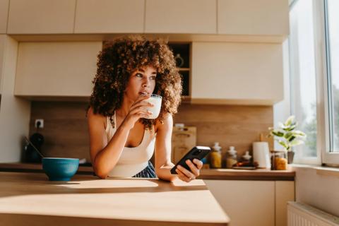 Adult drinking glass of milk in kitchen