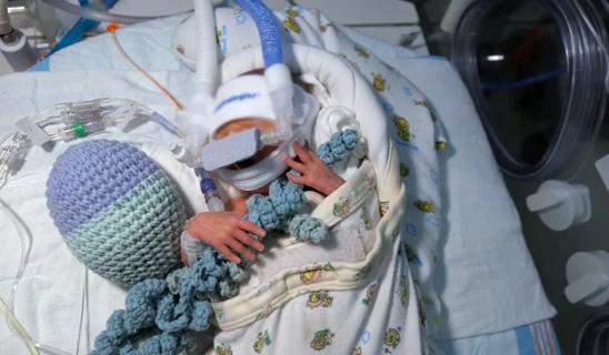 Baby holding crocheted octopi