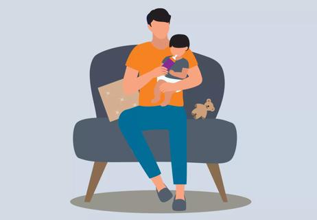 Parent holding baby and giving bottle to baby on a chair.