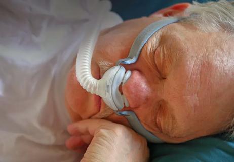 man asleep wearing CPAP