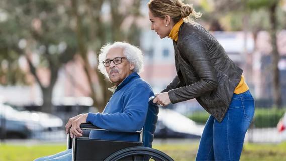 older man being pushed in wheelchair