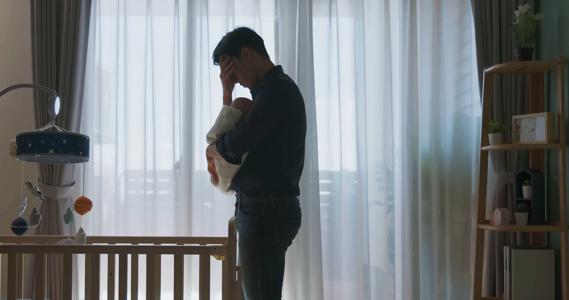 Stressed father holding newborn in the nursery