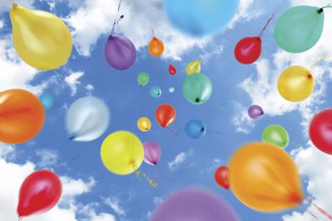 Multi-Coloured Balloons Move Upwards Into a Summer Sky