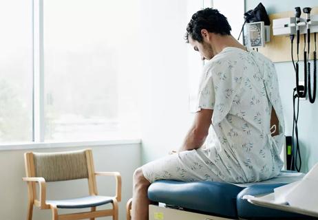 man in gown waiting inside doctor's office