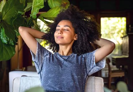 Woman deep breathing and relaxing at home