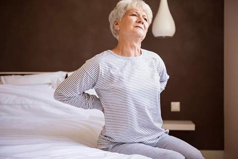 Woman in pain gets out of bed