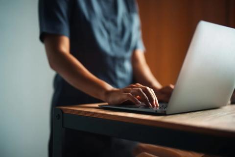 A clinician typing on a laptop
