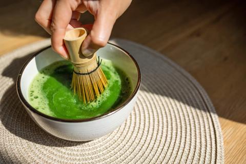 Hand stiring matcha in a bowl