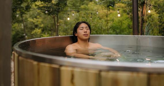 Person relaxing in hot tub with eyes closed