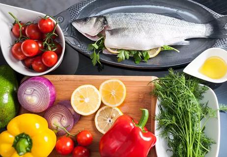 Fish, vegetables and other whole foods on a table.