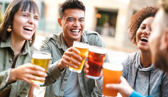 Group of happy, smiling friends raising a toast with glasses of beer