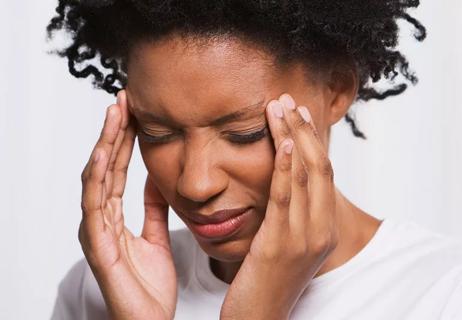 Person rubs temples of head while having a painful headache.