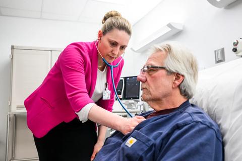 Doctor examining patient's heart with a stethoscope