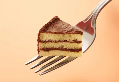 A tiny piece of cake sitting on a large fork