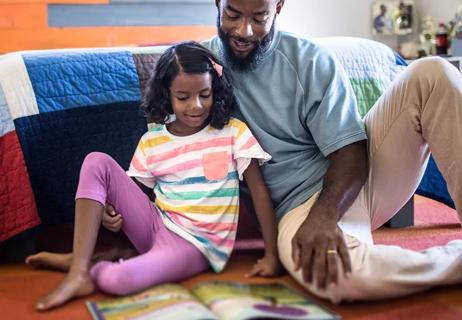 Father reading book with daughter