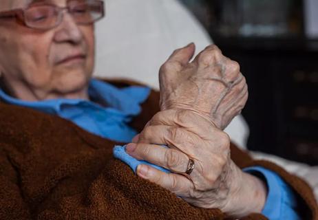 Elderly woman massaging arthritic wrist