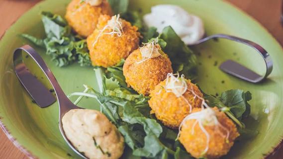 falafel on plate with spoons of sauce