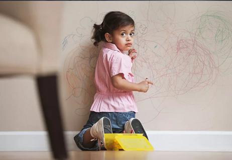 little girl in trouble drawing on wall