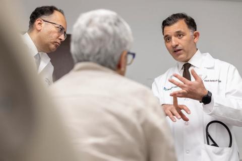 two doctors talking to an elderly patient