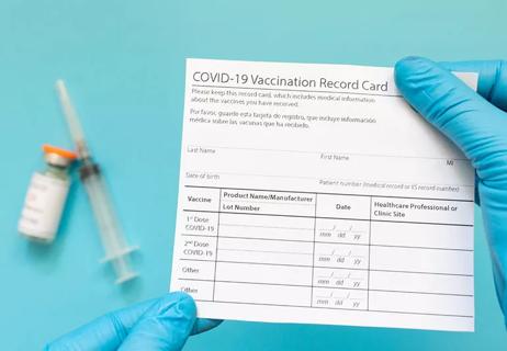 Healthcare worker holding a blank covid vaccine card.