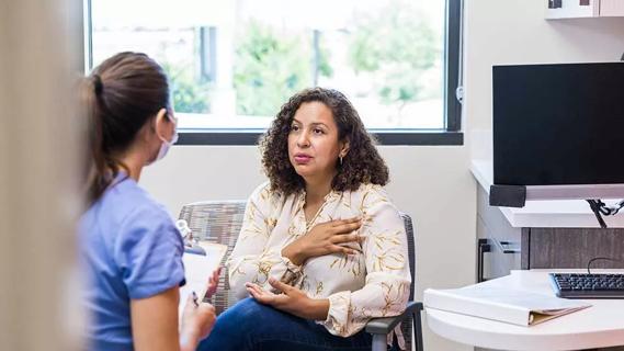 older female showing doctor where breast tenderness is