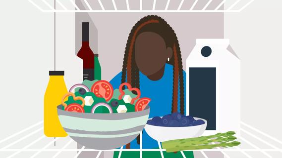 Person looking in fridge, filled with salad, milk, berries, veggies, juice