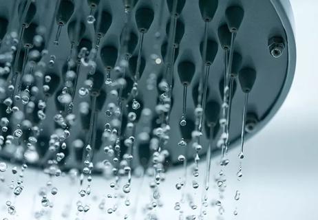 A close-up of streams of water pouring out of a shower head
