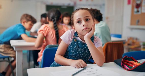 Daydreaming, distracted elementary school child at their desk