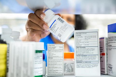 Pharmacist reaching for medication